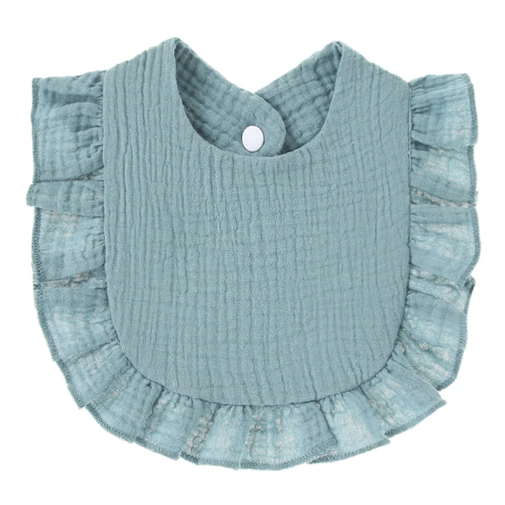A blue baby bib with a textured fabric and ruffled edges. It features a snap button for easy fastening at the neck.