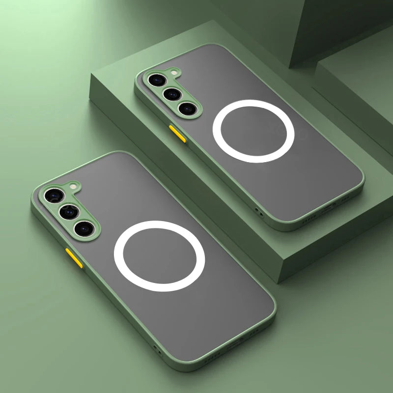 Two smartphones with gray and green cases display a circular design on the back. Each has three cameras and a yellow side button, resting on a green surface.