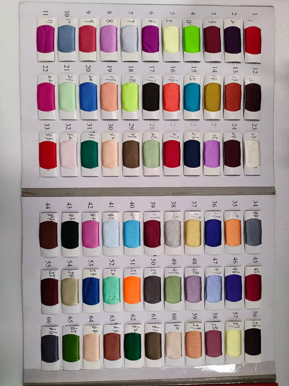 A display board featuring 67 fabric samples in various colors, arranged in rows. Each sample is numbered and showcases a range of vibrant and muted tones.