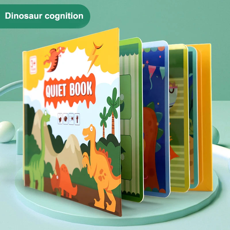 Children's "Quiet Book" with dinosaur theme featuring colorful illustrations of dinosaurs and plants under a yellow sky. Book pages are partially open, indicating interactive content.