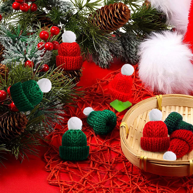 Miniature red and green knit hats with white pom-poms among pinecones and berries, on a red background. Some hats lie in a woven basket, creating a festive holiday scene.