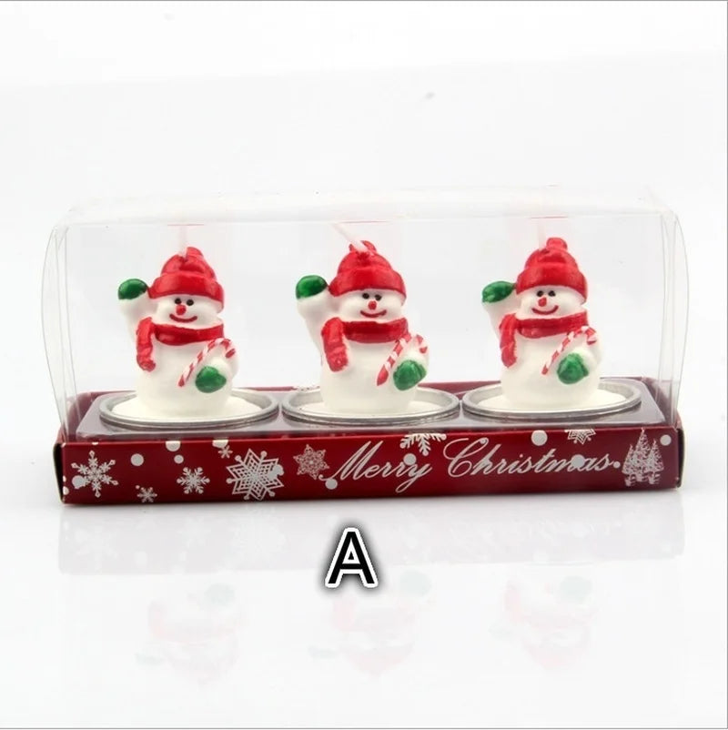 Three snowman-shaped candles in a red box labeled "Merry Christmas." Each snowman wears a red hat and scarf, holding green mittens and candy canes. 