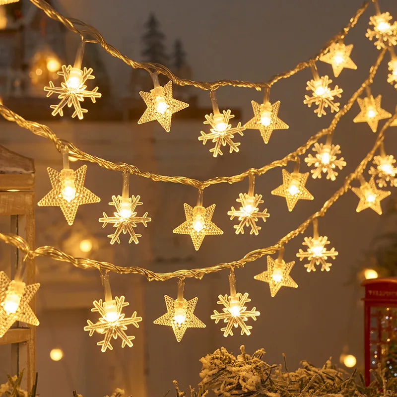 Warm glowing string lights shaped like stars and snowflakes hang festively against a blurred background. The soft illumination creates a cozy, holiday atmosphere.