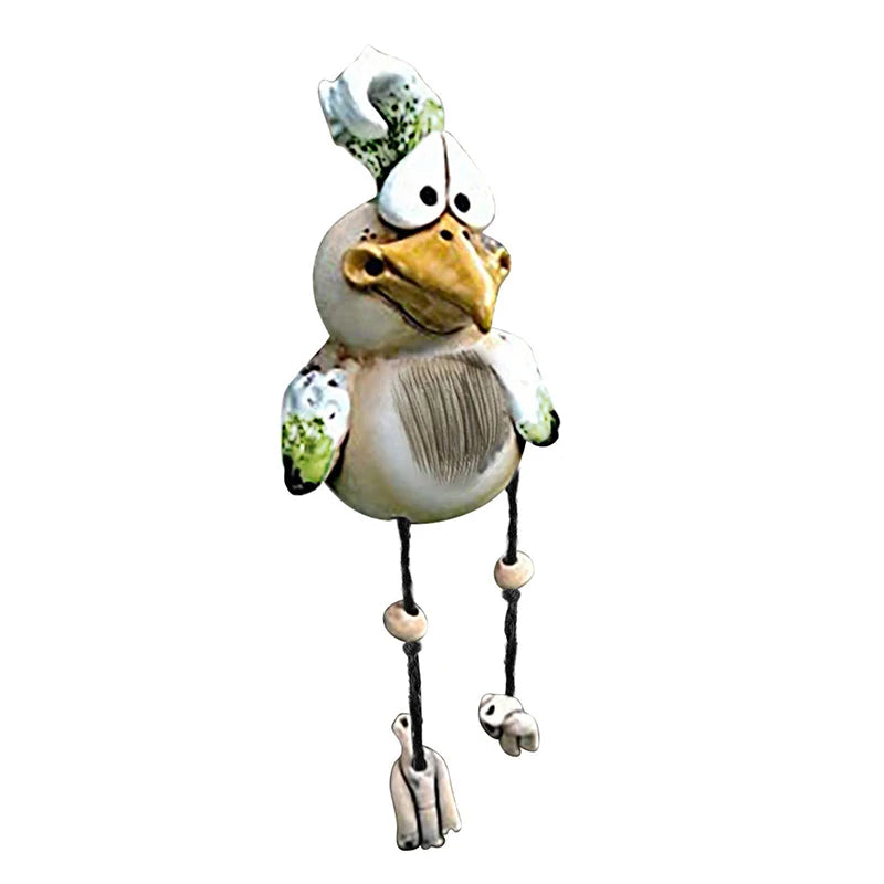 Quirky ceramic bird figurine with large eyes and a green tuft on its head. It has long string legs with wooden beads and whimsical feet.