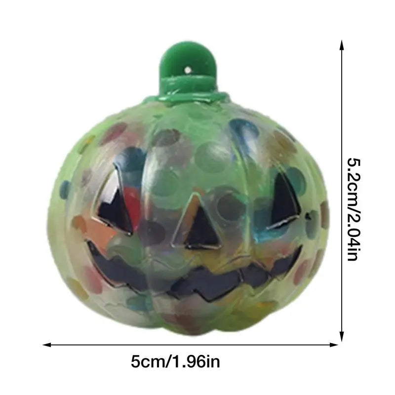 Green and multicolored jack-o'-lantern ornament with a smiling face, measuring 5.2 cm in height and 5 cm in width.