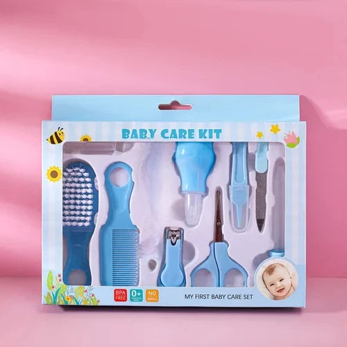 Blue baby care kit in a box on a pink background, including a brush, comb, scissors, nail clippers, and aspirator. Packaging features flowers, bees, and baby picture.