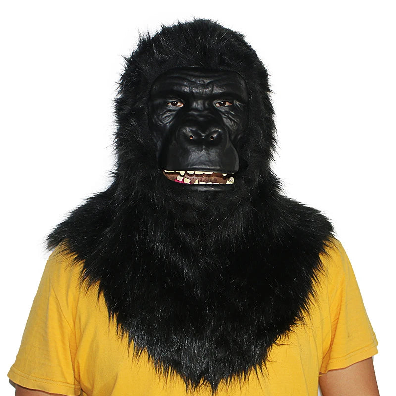 Person wearing a realistic black gorilla mask with fur, featuring a somber expression. They are dressed in a yellow shirt, against a plain white background.