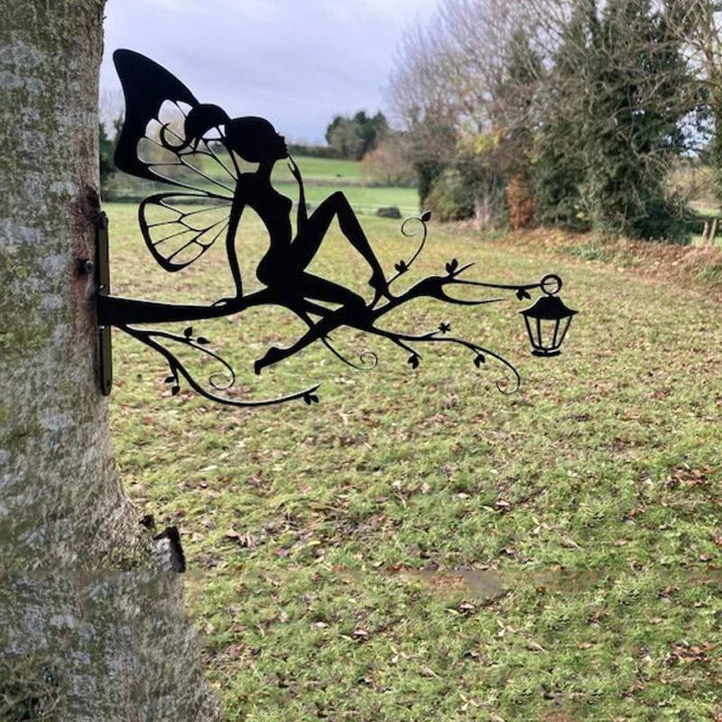Silhouette of a fairy sitting on a branch attached to a tree, against a rural landscape background. The fairy holds a small lantern, and fields stretch out in the distance.