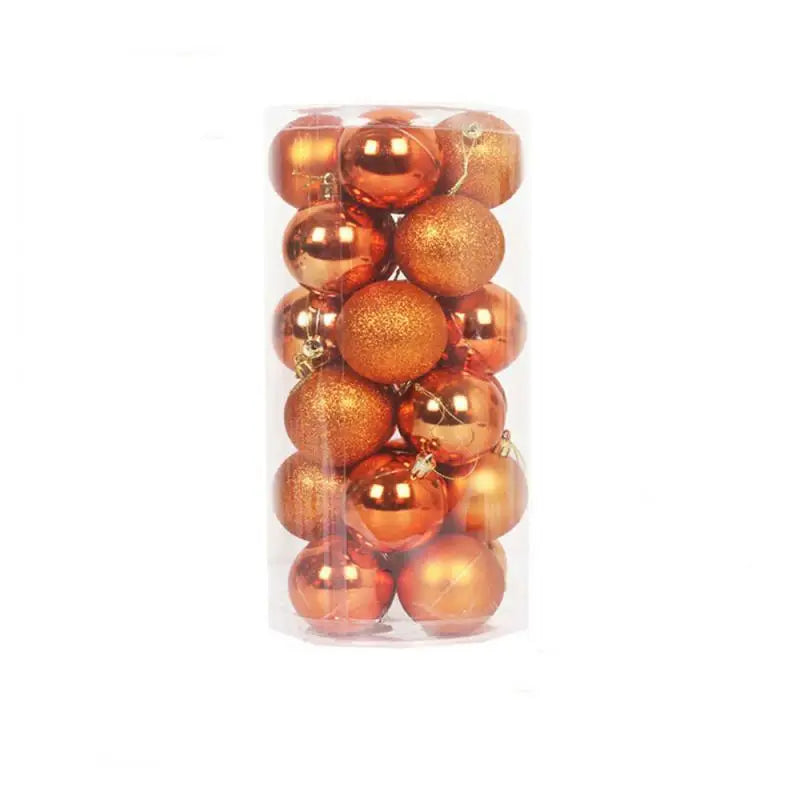 A clear cylindrical container holds glossy and glittery orange Christmas baubles, neatly stacked.