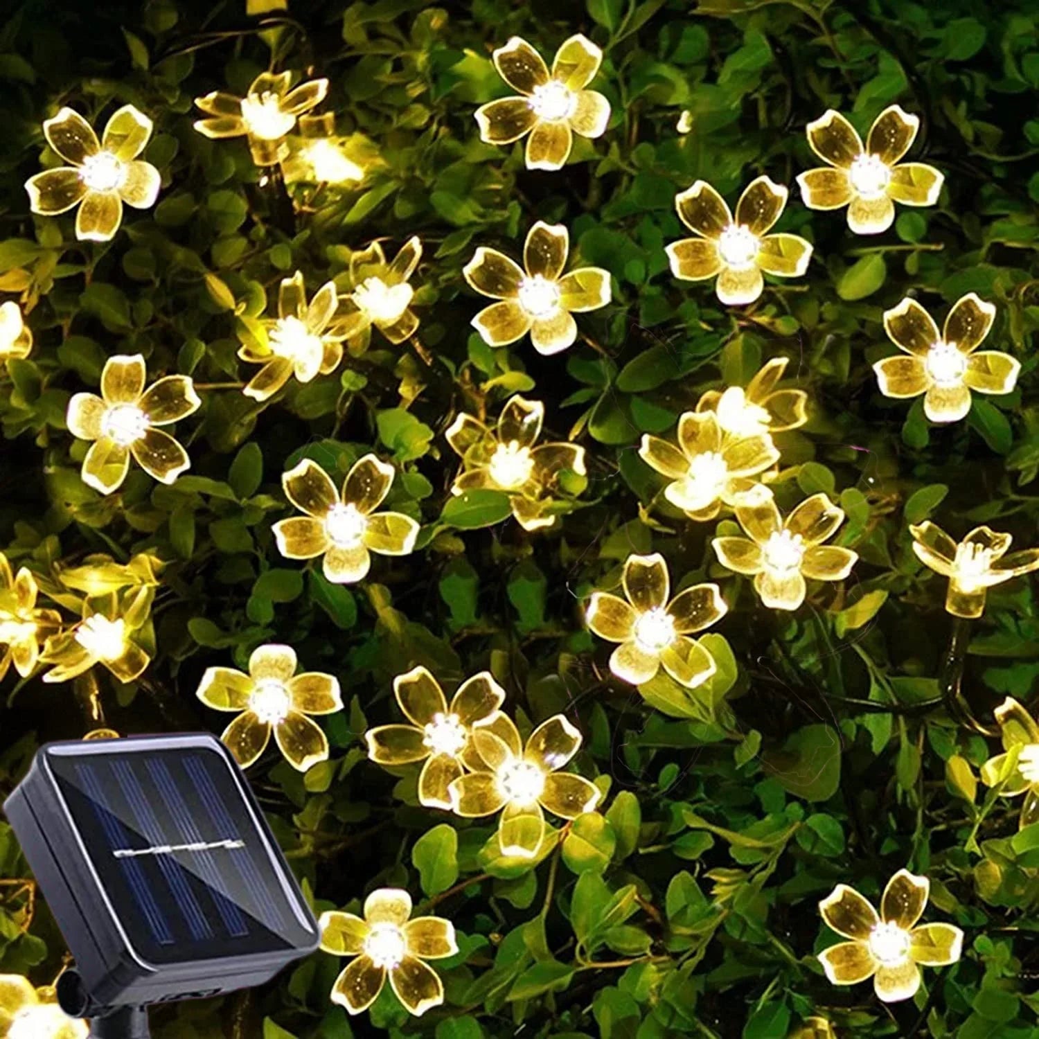 Glowing floral-shaped LED lights scattered among lush green foliage, with a visible solar panel for power.