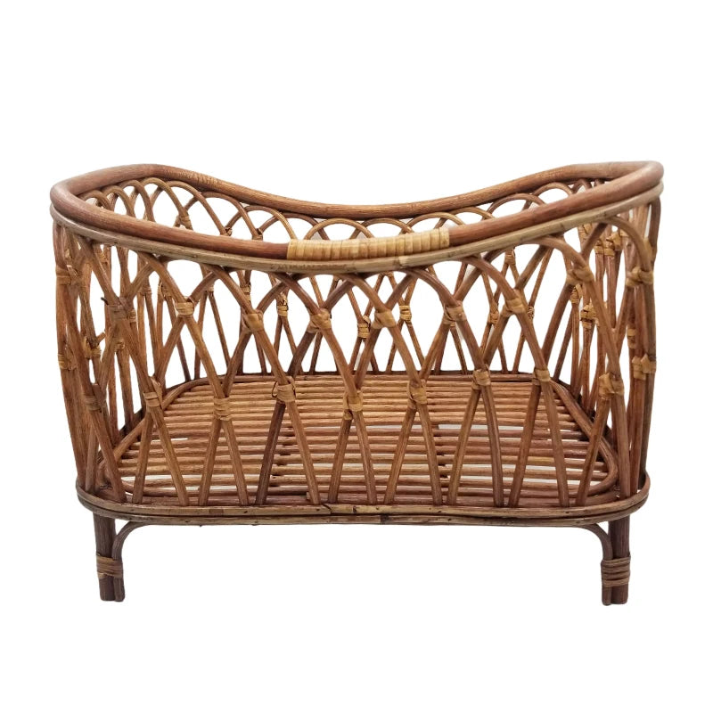 Woven rattan cradle with a sturdy frame and open lattice design. The natural finish and curved shape provide a classic, rustic appearance.