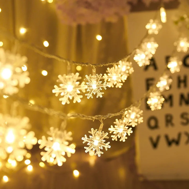 Warmly lit snowflake-shaped string lights hang against a soft-focus background, including a blurred alphabet chart, creating a cozy, festive atmosphere.