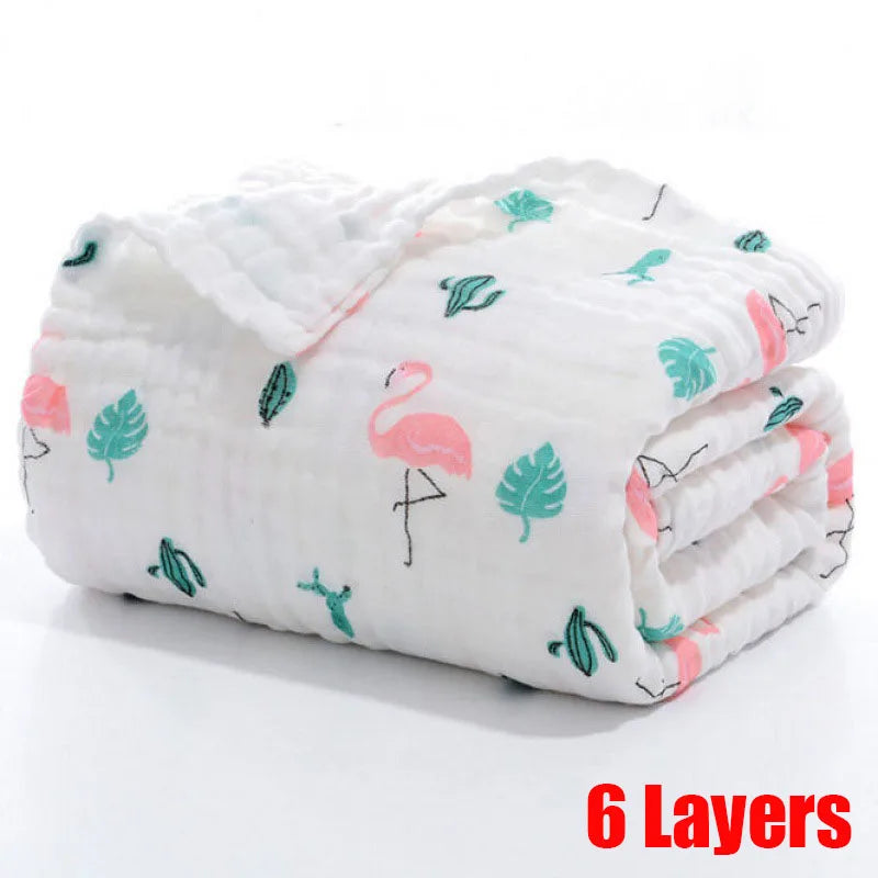 White quilt with pink flamingos and green leaves, folded neatly. "6 Layers" written in bold red text at the bottom right corner.
