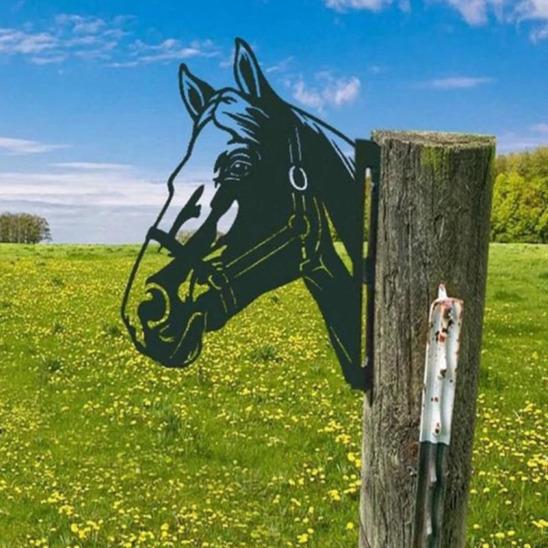 Metal horse head silhouette attached to a weathered wooden post stands in a vibrant field of yellow flowers under a clear blue sky.