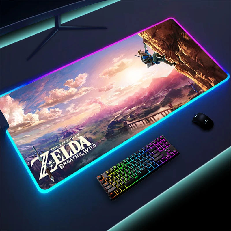 Gaming desk setup with an RGB-lit mousepad featuring "The Legend of Zelda: Breath of the Wild" artwork. Includes a colorful keyboard and a black mouse on a dark surface.