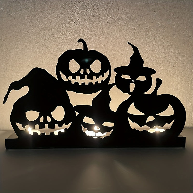 Silhouetted Halloween decoration featuring five jack-o'-lanterns with various spooky expressions, backlit to create an eerie glow against a blank wall.