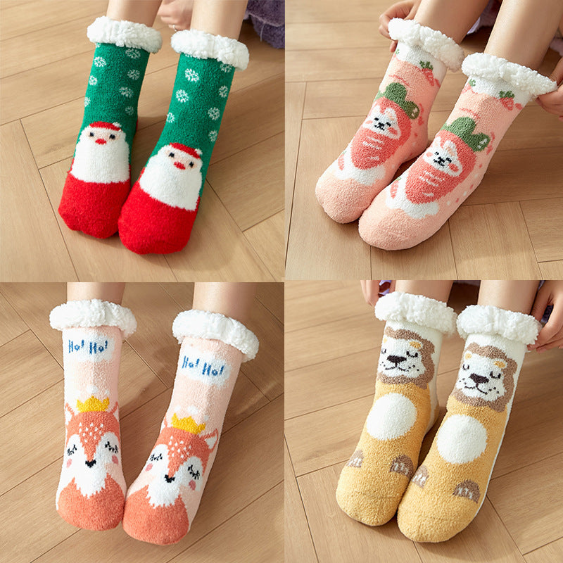 Four pairs of colorful, fluffy socks with festive designs: Santa, strawberries, a fox, and a lion. Each pair is worn by a person seated on a wooden floor.