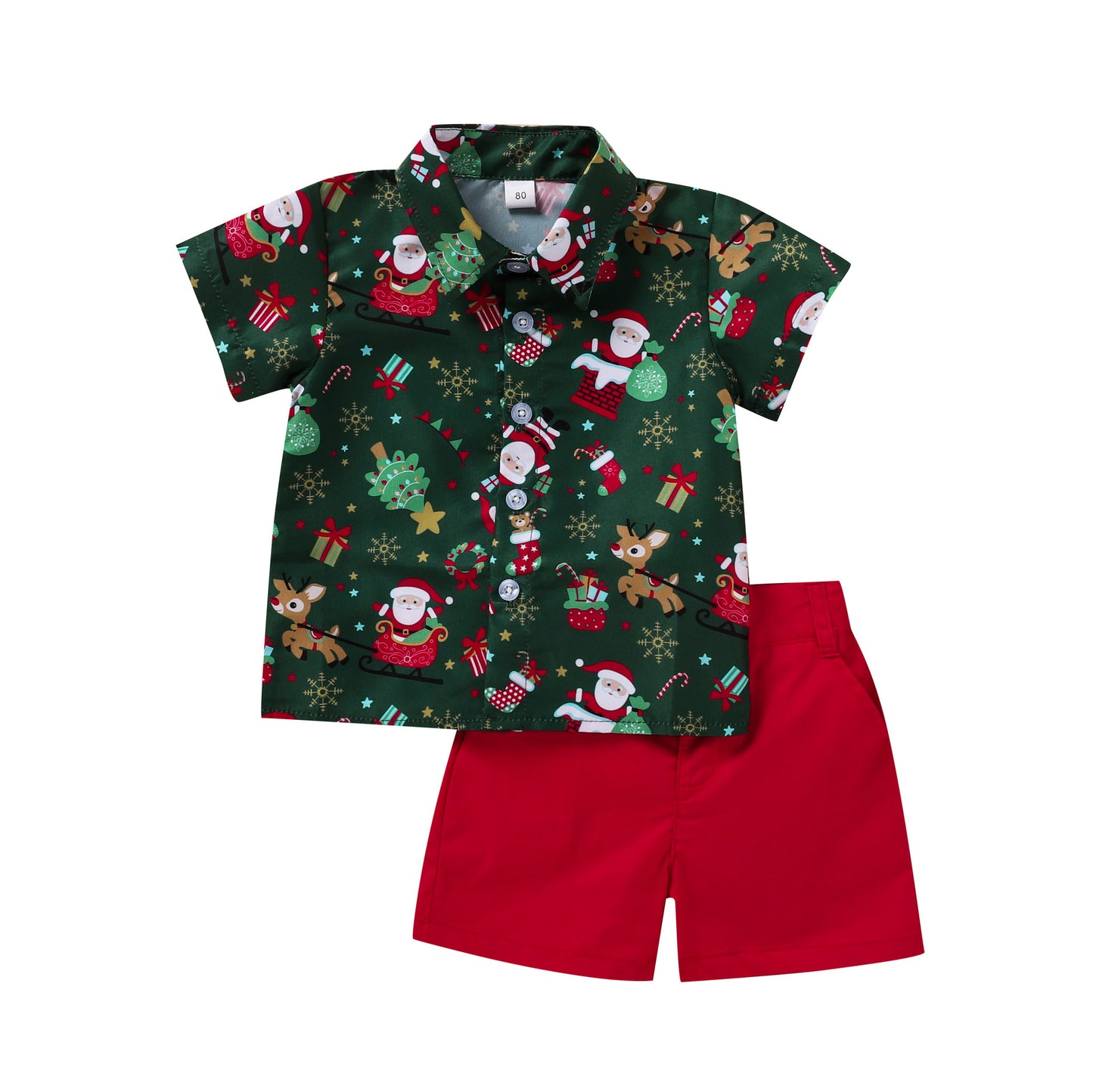 Festive toddler outfit with a green Christmas-themed shirt featuring Santa, reindeer, and gifts, paired with solid red shorts.