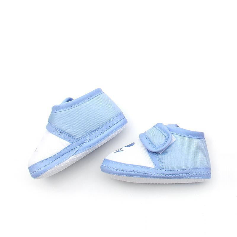 Light blue and white baby shoes with Velcro straps are placed on a white background. The shoes are lightweight and feature a simple design, perfect for infants.