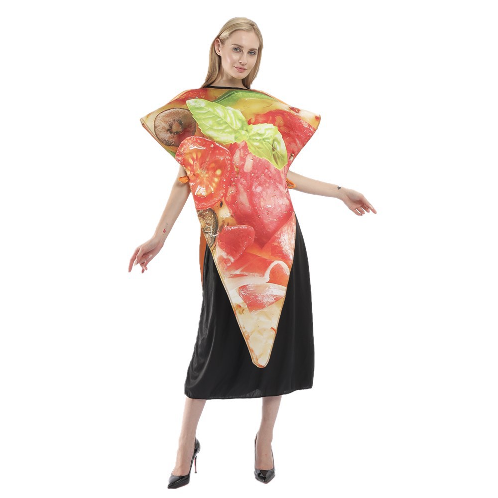 A woman stands wearing a large pizza slice costume, featuring vibrant toppings like tomatoes and basil. The costume is triangular, resembling a slice of pizza, and covers her torso. She is dressed in black beneath the costume and poses with one leg slightly forward and arms relaxed.