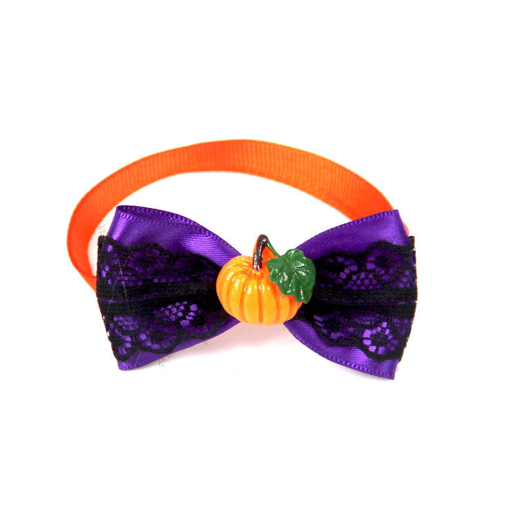 Purple and black lace bow with a small pumpkin centerpiece on an orange headband, creating a Halloween-themed accessory.