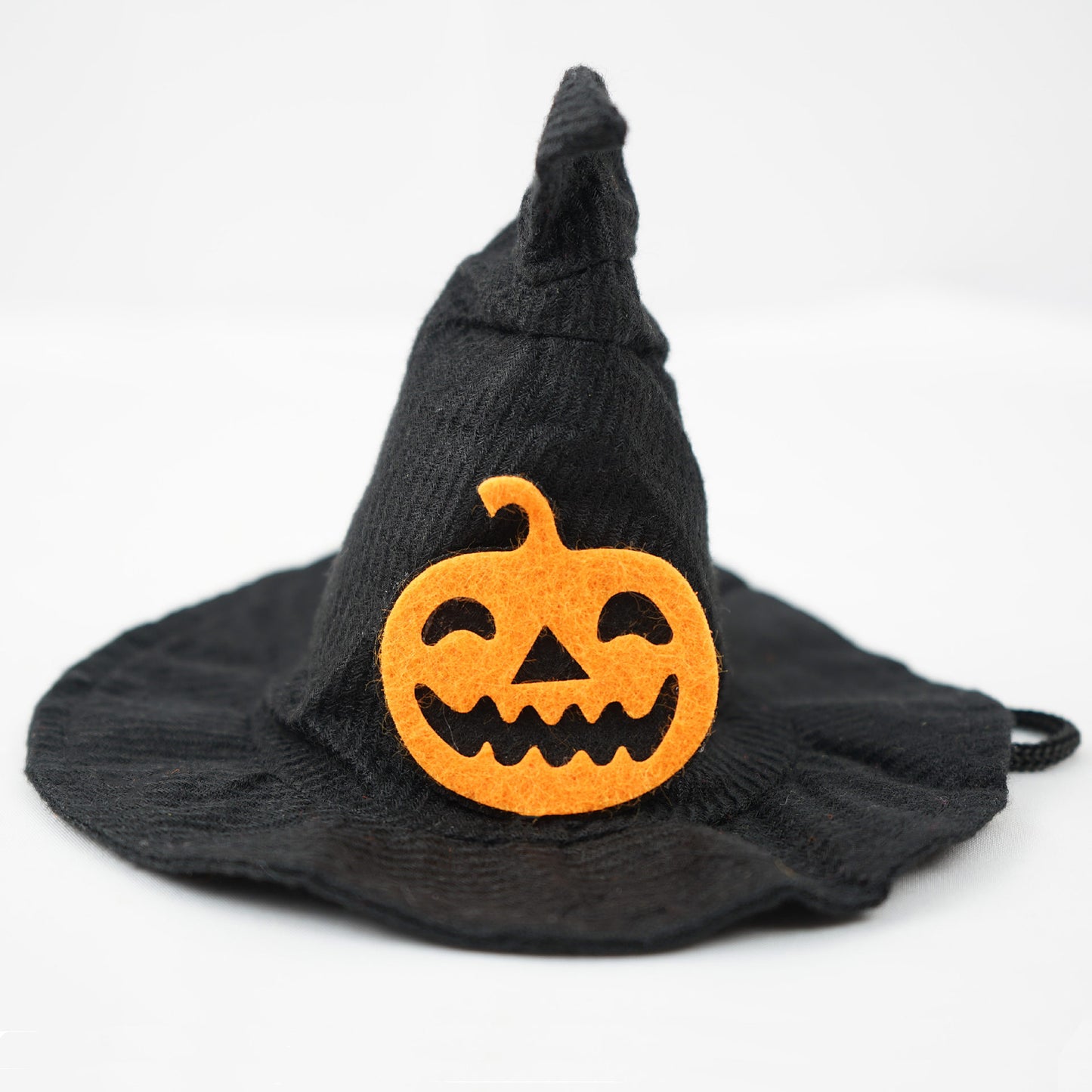 Black witch hat with a curved tip, adorned with a smiling orange felt jack-o'-lantern decoration.