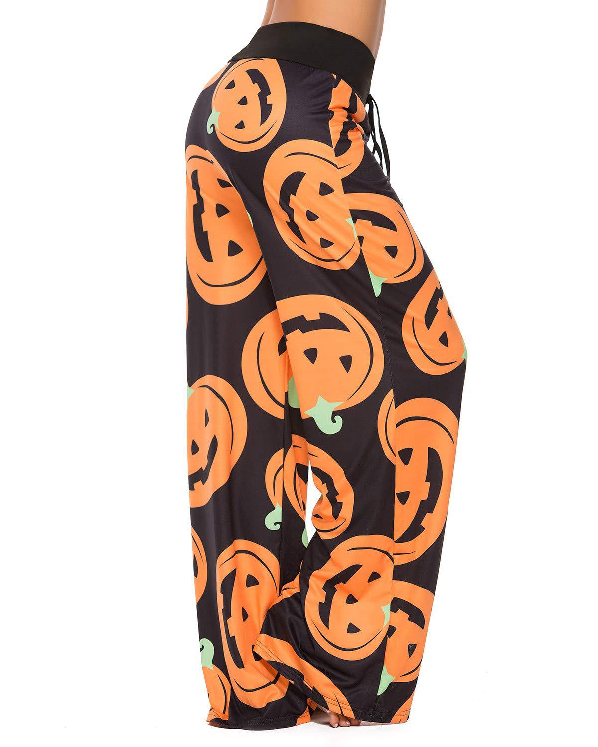 Wide-leg pants with a black base featuring vibrant orange jack-o'-lanterns and green stems. A person models the pants, highlighting the playful Halloween-themed design.