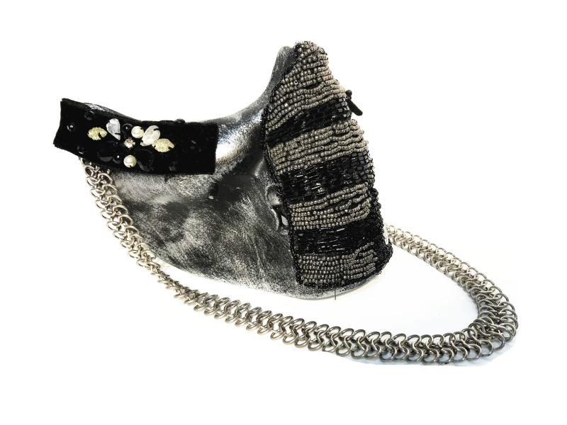 A stylish accessory features metallic fabric with black and silver beadwork, decorated with rhinestones and pearls, and finished with a thick silver chain strap.
