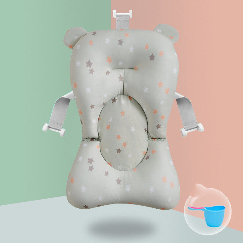 Baby bath cushion with star pattern, side straps, and a headrest, set against a split green and peach background. A small image of a blue ladle is in the corner.