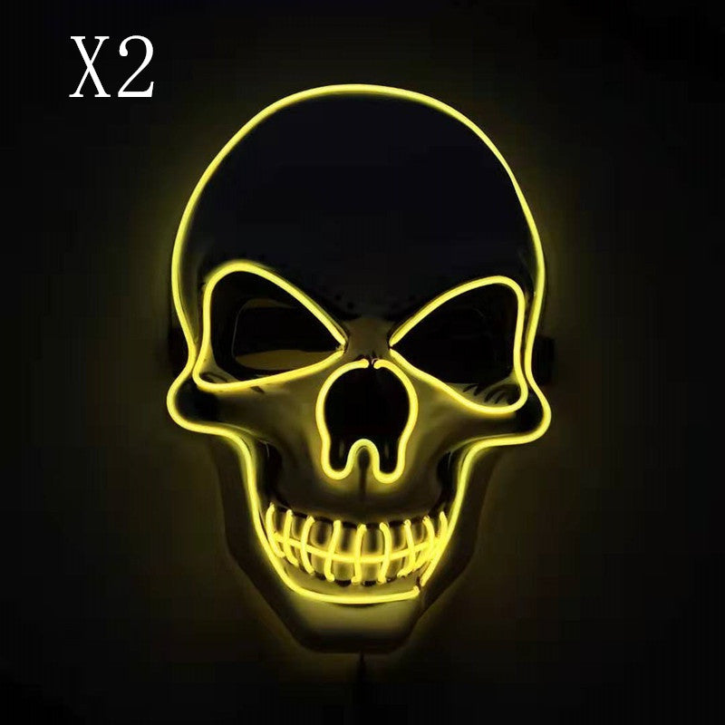 Glowing neon outline of a skull on a dark background with "X2" in the top left corner. The skull features prominent eye sockets and teeth, illuminated in bright yellow.