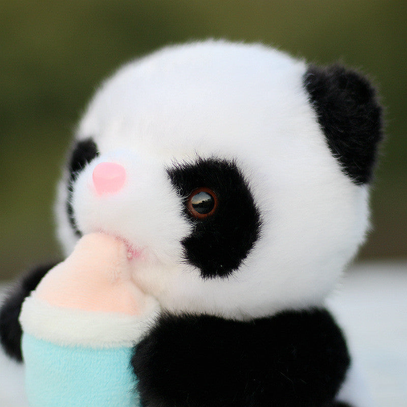 A fluffy panda plush toy with black and white fur is holding a small ice cream cone. It has a cute pink nose and is set against a blurred green background.