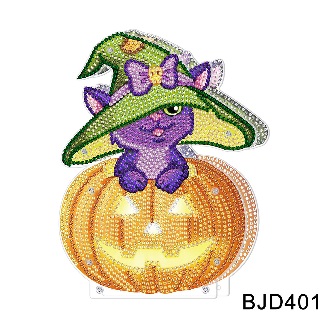 A purple cat wearing a witch hat, adorned with rhinestones, sits on an orange jack-o'-lantern with a glowing face. The design is marked with "BJD401" at the bottom right.
