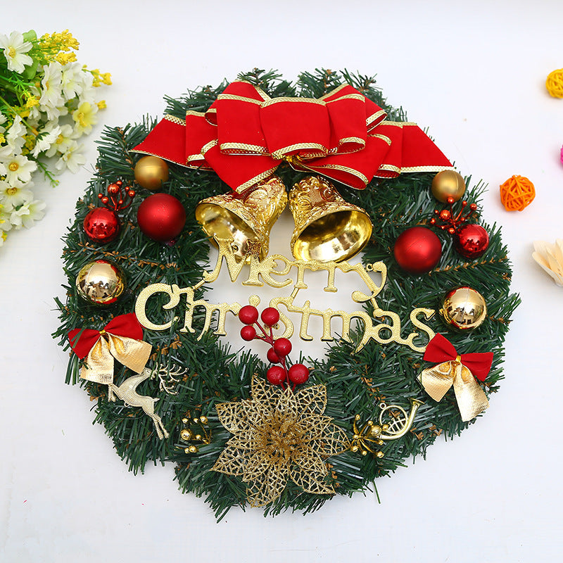 Festive Christmas wreath adorned with golden bells, red and gold ornaments, a red bow, faux berries, and a "Merry Christmas" sign. White flowers lie adjacent.