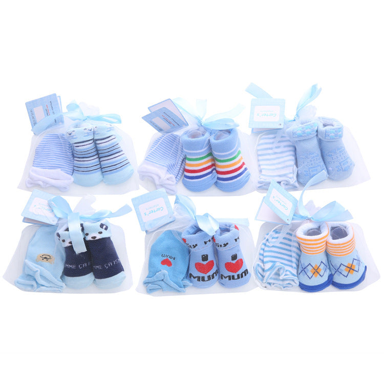 Six pairs of baby socks in various blue designs, including stripes, rainbows, and prints, each set tied with a blue ribbon and displayed on white cards.
