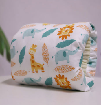 Colorful cloth diaper featuring a playful pattern of giraffes, elephants, lions, and leaves in orange, teal, and brown. The diaper is neatly folded on a white surface.