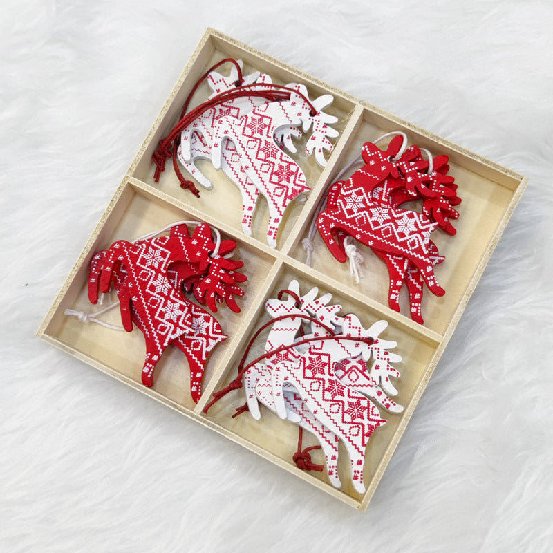 Four compartments in a wooden box hold red and white reindeer ornaments with intricate patterns, set on a plush white surface.