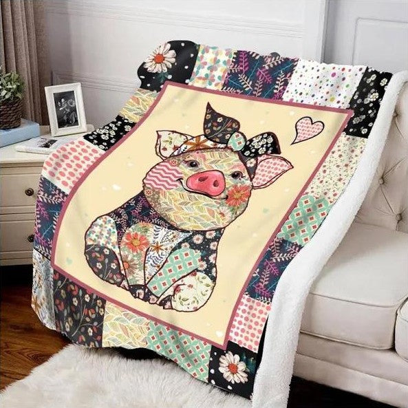 A patchwork blanket draped over a white sofa, featuring a colorful pig with a bow and heart pattern. It has various patterned squares with floral and geometric designs.