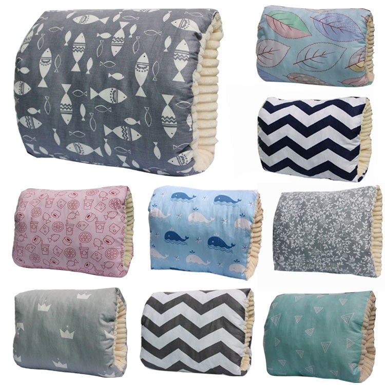 A collection of nine plush pillows with different patterns, including fish, leaves, zigzags, whales, crowns, geometric shapes, and floral designs in various colors.