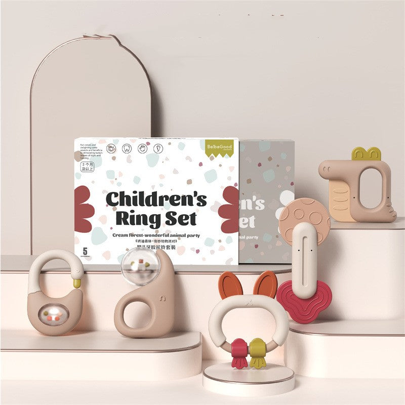 Children's Ring Set with animal-themed designs in pastel colors displayed on white shelves, featuring rings resembling swans, rabbits, and crocodiles. Packaging visible in the background.
