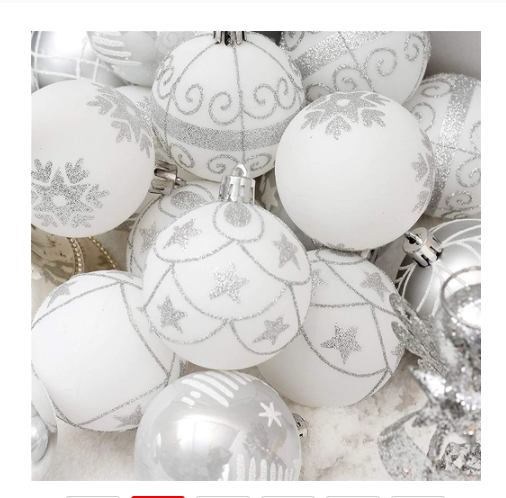 A collection of elegant white Christmas ornaments with silver glitter patterns, featuring varied designs like stars and swirls, creating a festive and sophisticated appearance.
