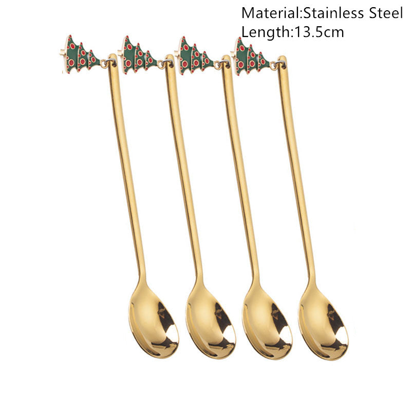 Four gold stainless steel spoons, each topped with a decorative Christmas tree, are arranged side by side. The spoons are 13.5 cm long.