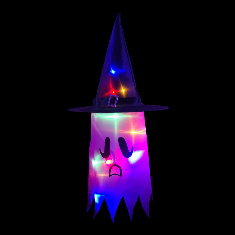 Illuminated ghost decoration wearing a witch hat, featuring colorful lights and a sad face, set against a dark background.