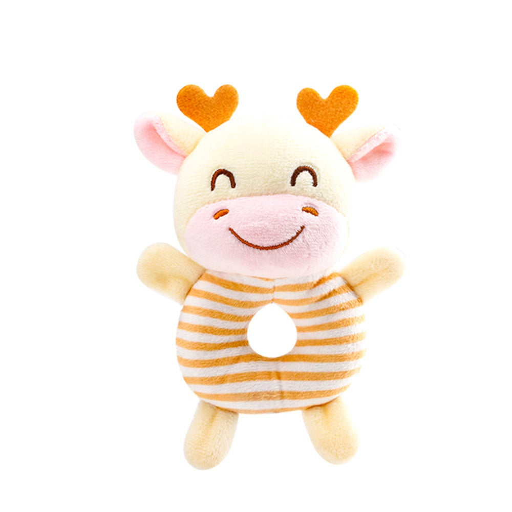 Cute plush toy shaped like a smiling yellow cow with small orange horns, pink ears, and a striped donut-shaped body with a central hole, against a white background.