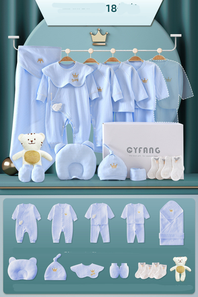 Baby clothing set in light blue, featuring outfits with crown embroidery, a blanket, a hat, socks, and a plush teddy bear, displayed against a teal background.