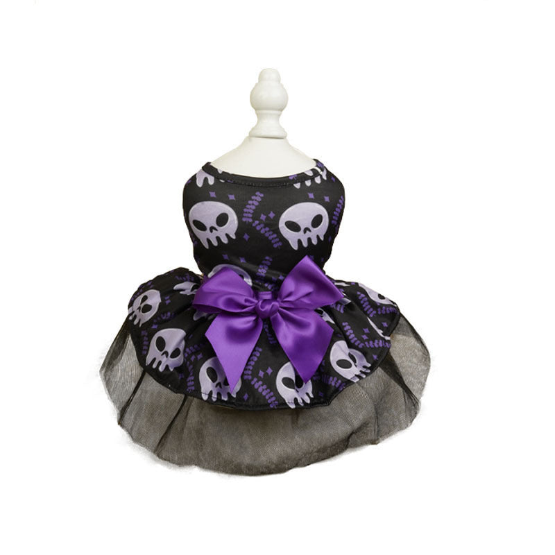 Black pet dress with white skull pattern, accented by a large purple bow. The skirt features a layered black mesh detail, displayed on a white stand.