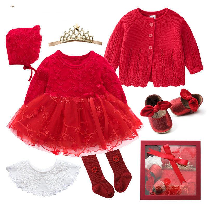 Red infant outfit set including a dress with lace skirt, cardigan, bonnet, bow-tie shoes, and accessories like a gold tiara, red socks, and white lace collar.