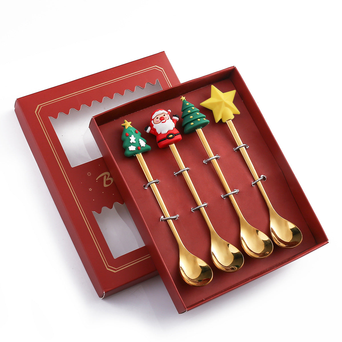 Set of four gold spoons with festive handles featuring Santa, Christmas trees, and a star, presented in a red decorative box with a clear window.