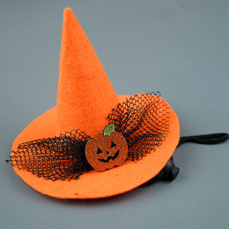 Orange felt witch hat adorned with a glittery pumpkin and black mesh ribbon, set on a grey background.