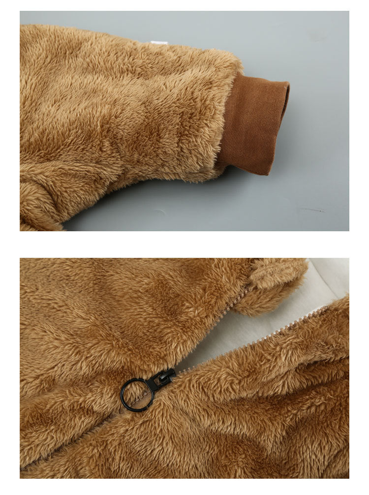 Close-up of a brown fuzzy jacket showing a ribbed cuff and a black zipper with a round pull ring. The soft fabric adds texture and warmth.