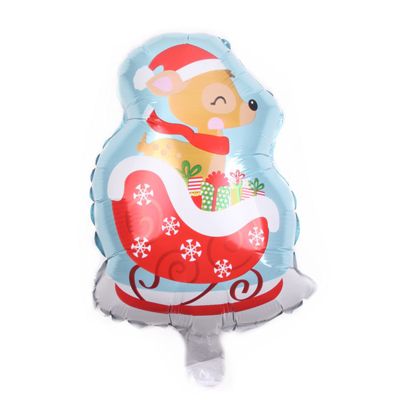 A festive balloon depicting a reindeer wearing a Santa hat and scarf, seated in a red sleigh adorned with snowflakes, surrounded by colorful wrapped gifts.